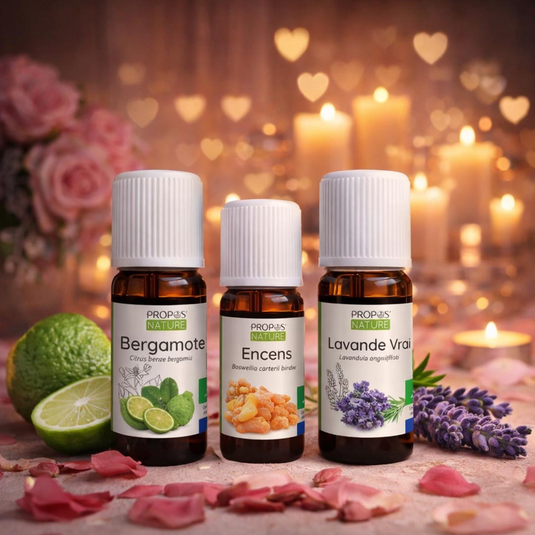 Three essential oil bottles with labels on a decorative background with flowers and candles.