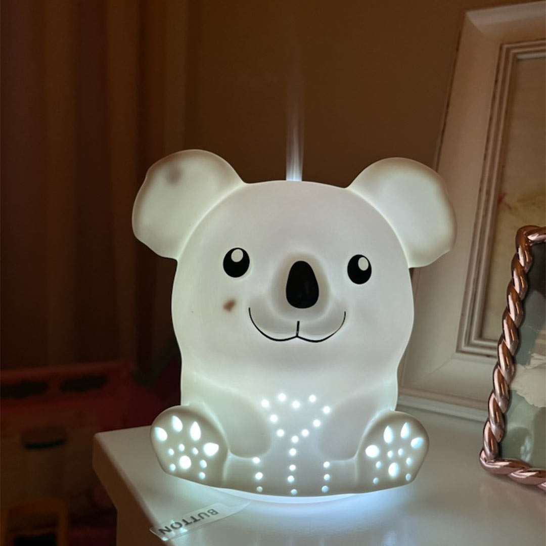 Innobiz KOA aroma diffuser on night stand in the dark with lights and mist