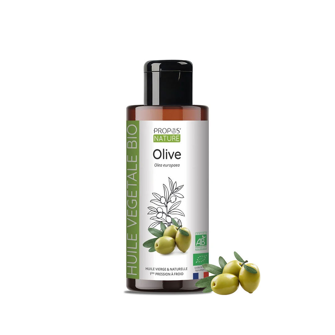A bottle of Propos Nature Bio Olive Vegetable Oil next to three green olives on a plain white background.